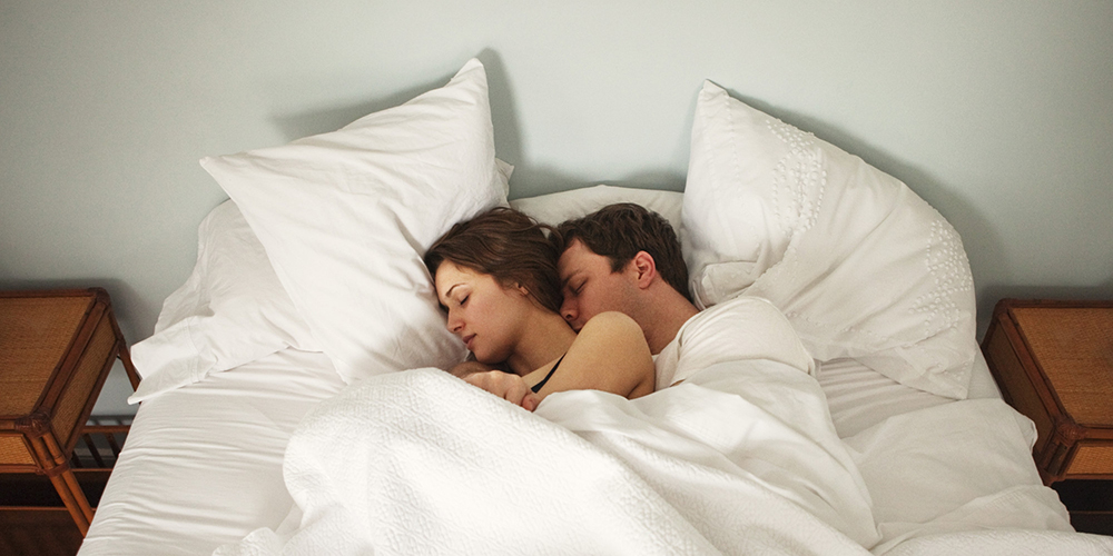 Couple Lie in Bed Holding Each Other